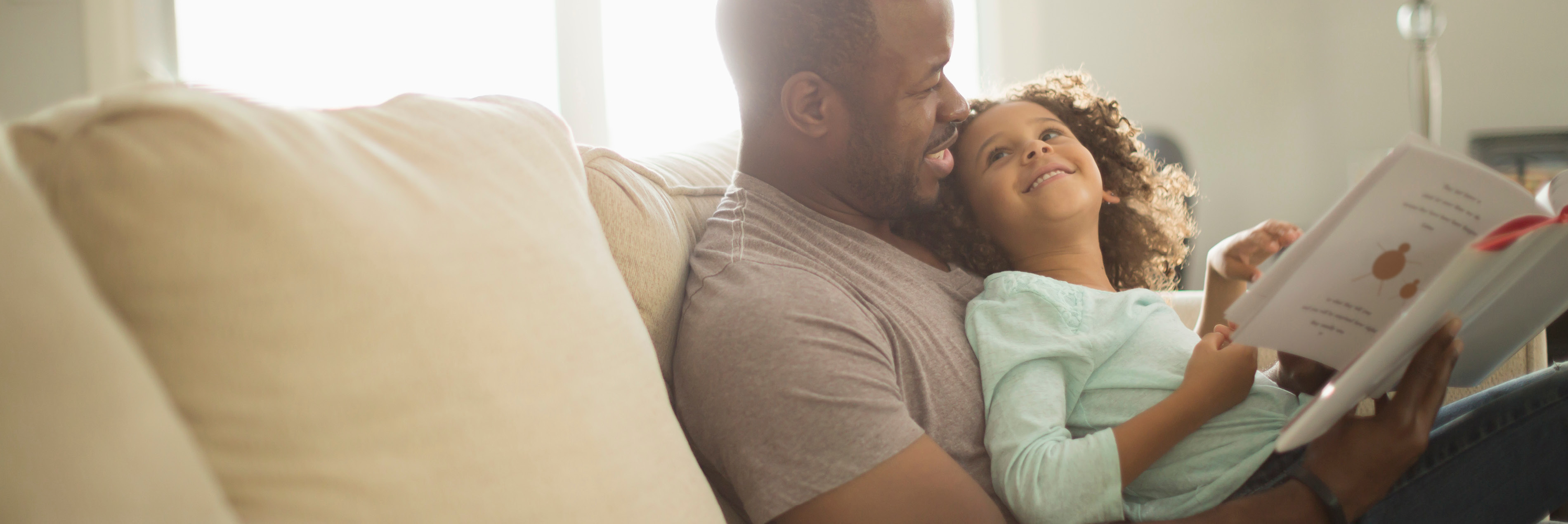 Father reading daughter a book