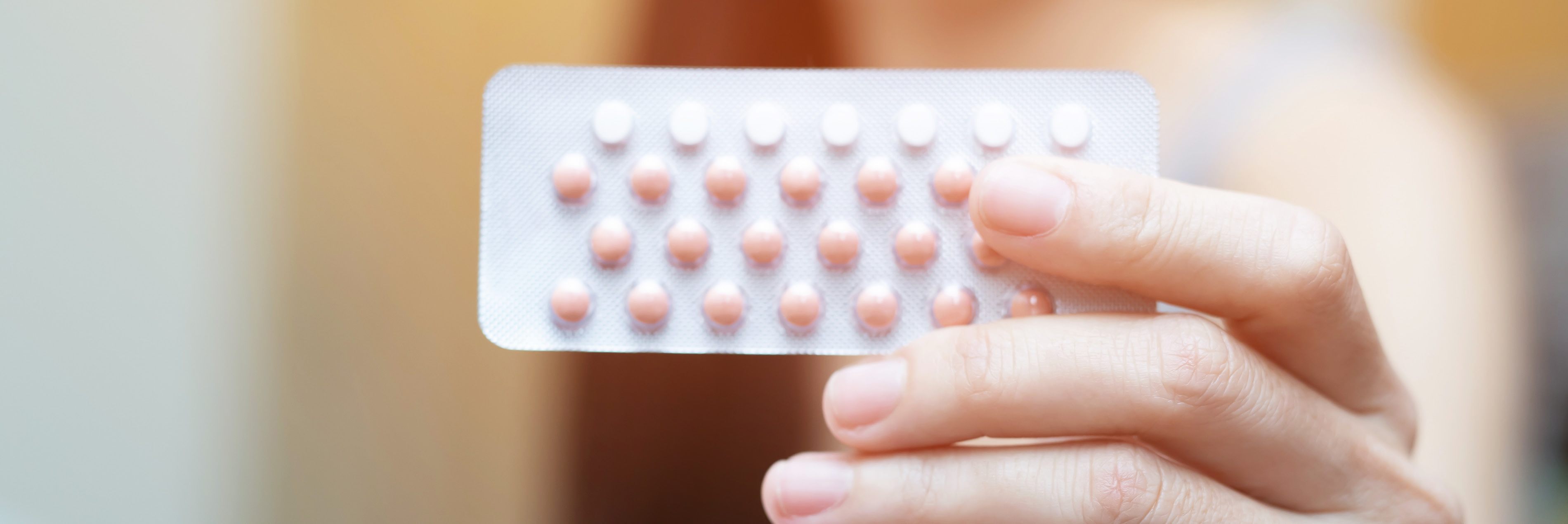 Hand holding birth control pills