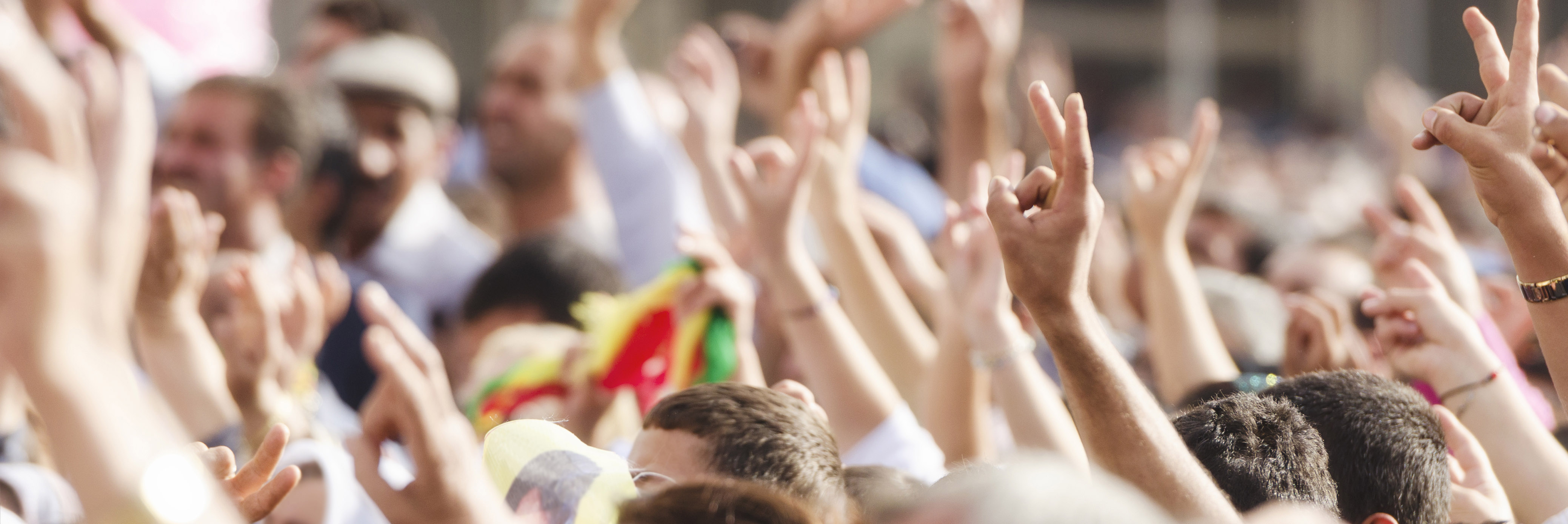 Crowd of people raising peace sign