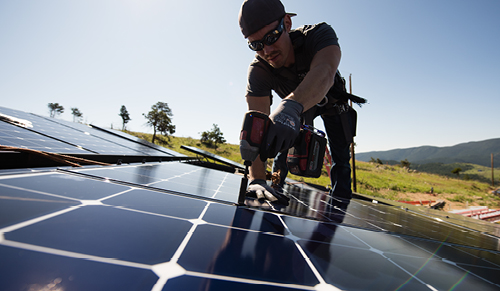 Namaste Solar employee drilling solar panel