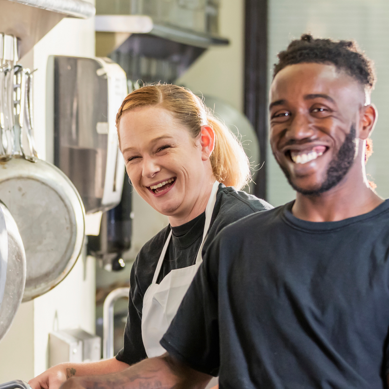 A man and woman working in the kitchen