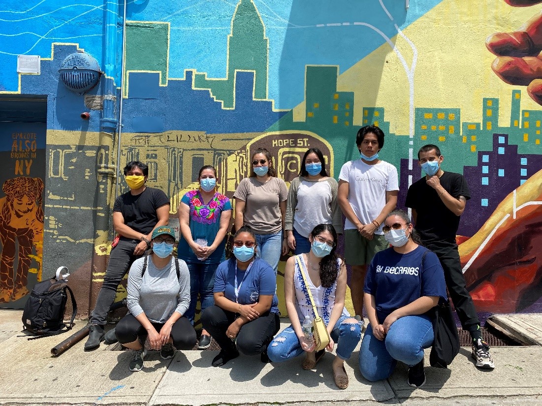 People from Mixteca with facemasks on standing in front of a wall